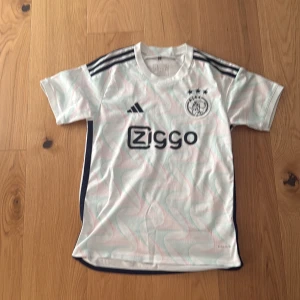 AJAX Fotboll tröja vit - Säljer nu min ajax t-shit eftersom att jag inte har någon användning ut av den längre. Jätte fint skick. Pris kan diskuteras 