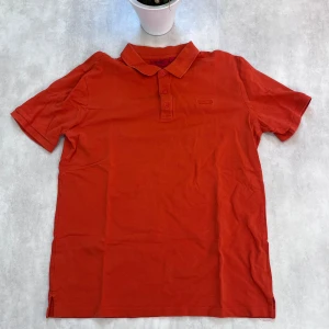 Röd piké t-shirt från Hugo Boss - 🔴 Hugo Boss Piké – Stilren & Bekväm Säljer en röd Hugo Boss pikétröja i storlek L med klassisk krage, knappar framtill och korta ärmar. Regular fit – perfekt balans mellan avslappnat och stiligt.  🧵 Skick: Mycket bra 💸 Pris: Endast 99 kr!  En piké som passar lika bra till vardags som till sommarens tillfällen. 📩 Skicka DM om du vill köpa!