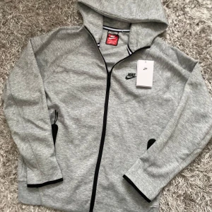 Grå Nike tech - Grå nike teck i nytt skick. Säljer den för att tröjan är liten på mig