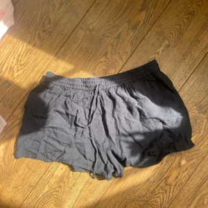 Svarta bomullsshorts med resår - Svarta shorts i mjukt bomullsmaterial med elastisk midja och avslappnad passform. Perfekta för varma dagar eller som loungewear. Klassisk och enkel design utan synliga detaljer.