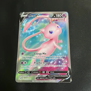 Pokémon Mew V (Fusion Strike) 250/264 - Samlarobjekt! En holografisk Pokémonkort med Mew V från Fusion Strike-serien. Perfekt för dig som gillar Pokémon, samlar på kort eller vill ha något unikt till din samling. Kortet har cool design och är i fint skick.