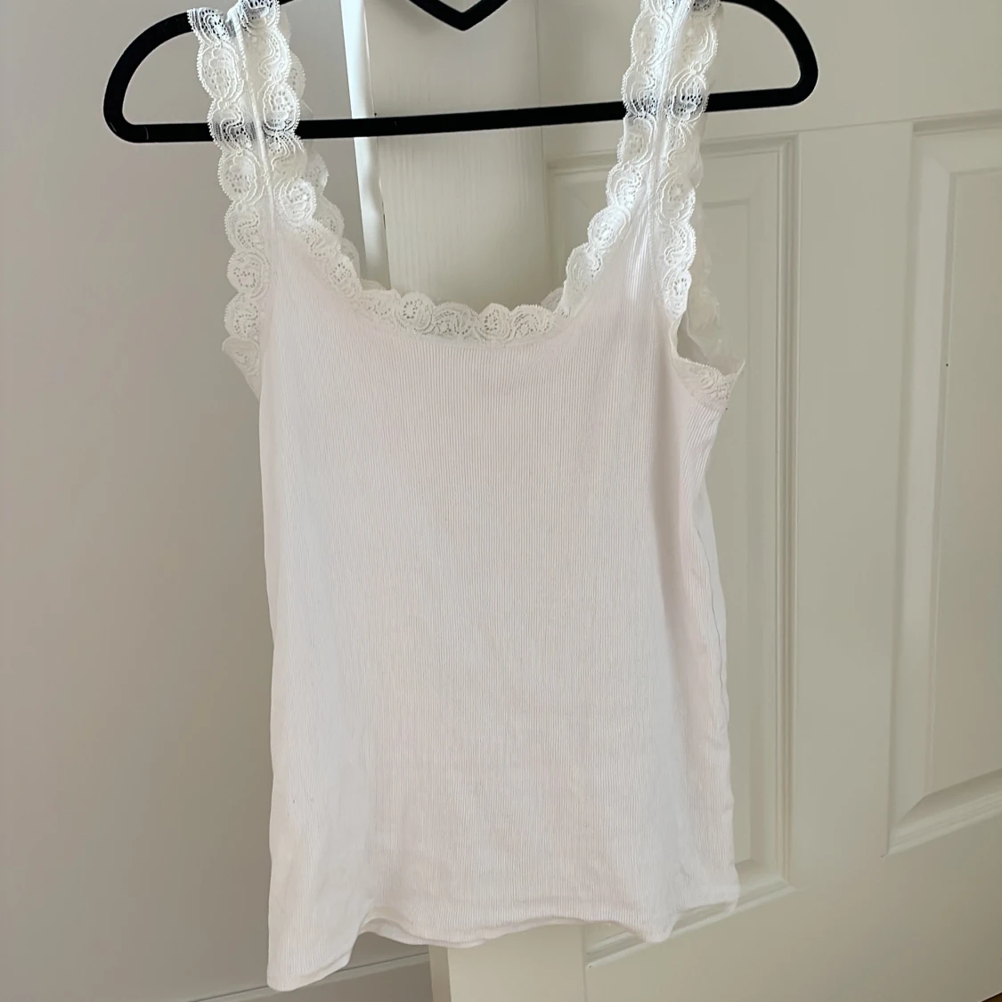 Vit ribbad linnetopp med spetsdetaljer