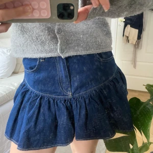 Mörkblå volangkjol i jeans - Säljer en söt mörkblå jeanskjol med volang. Aldrig nånsin använd!