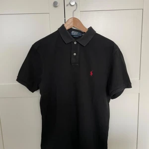 Svart pikétröja från Polo Ralph Lauren - Klassisk svart pikétröja från Polo Ralph Lauren i perfekt skick. Tröjan är i storlek L (slim fit), skriv om ni har några frågor! 