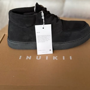 Svarta herr mockasiner från INUIKII - Säljer ett par helt oanvända INUIKII Moccasin Sneakers. Skorna kommer i originalförpackning och är i perfekt skick. En trendig och stilren vintersko för män med högkvalitativa material och en unik design som passar både vardag och promenader i kylan. Perfekt för dig som vill kombinera stil med funktion. Nypris: 3500kr     •   Modell: Inuikii Moccasin Sneaker    •   Storlek: 42    •   Skick: Oanvända (helt nya)    •   Originalförpackning: Ja  