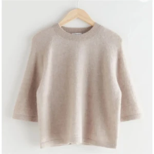 & other stories tröja - Säljer en supermjuk och stilren beige stickad tröja med rund halsringning och trekvartsärmar. Perfekt för lager-på-lager och passar till många olika outfits. Enkel och tidlös design. Passar xs-S