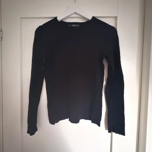 Svart finstickad  långärmad tröja från Mango - En svart långärmad tröja från Mango som är finstickad. Tröjan har en rund halsringning och slits vid ärmsluten för en extra detalj. Perfekt basplagg att styla till olika outfits.