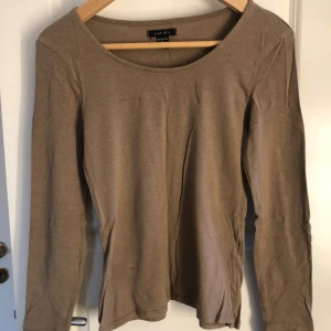 Ljusbrun långärmad topp - Säljer en enkel, ljusbrun, långärmad topp från Amisu i storlek M men sitter som en S. Tröjan har rund halsringning och är tillverkad i ett mjukt bomullsmaterial 🤎