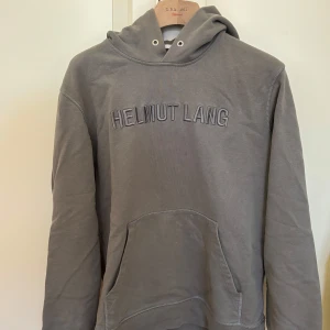 Helmut Lang grå hoodie / tröja, storlek S - Säljer min hoodie från Helmut Lang då den aldrig används längre. Inköpt på Harry’s i London för några år sedan för 3000 kr. I fint begagnat skick, tecken på användning finns (se bild 5 t ex).