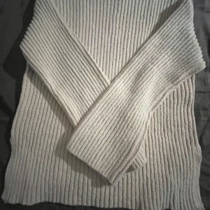 Beige ribbad stickad tröja från Gina Tricot - Säljer en beige ribbad stickad tröja från Gina Tricot i storlek XS. Tröjan har lång ärm och en klassisk, enkel design som passar perfekt till många olika outfits. Supermjuk och skön att ha på sig!