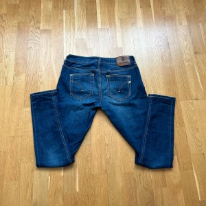 Blå jeansbyxor från Dondup - Säljer ett par klassiska blå jeansbyxor från Dondup med snygga kontrastsömmar och unika broderade detaljer på bakfickorna. Byxorna har normal passform och är tillverkade i jeansmaterial. Perfekta för en stilren vardagslook. Riktigt stil ren med en fin detalj dör det är ett D på bak fickan ny pris ca 2500 riktigt fina inför sommaren och passar med allt 😊🤩