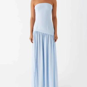 Ljusblå axelbandslös långklänning - Säljer en ljusblå axelbandslös långklänning med figurnära överdel och utsvängd kjol. Klänningen har en asymmetrisk midjesöm och faller snyggt ner mot golvet. Perfekt för dig som vill ha en stilren och elegant look.