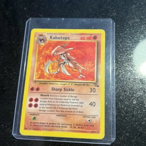 Kabutops - Samlarkort från Pokémon med Kabutops, en fossil-Pokémon. Perfekt för dig som gillar nostalgi, samlar på Pokémonkort eller vill ha något unikt i din samling. Kortet är skyddat i plastfodral och har coolt motiv och detaljerade stats. En klassiker för alla Pokémon-fans!