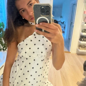 Prickig klänning - Vit klänning med svarta prickar. Halterneck design och piffig nertill. Storlek S men skulle äga att den mer passar en S/M. Lite stor på mig nämligen. 