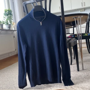 Mörkblå stickad tröja med dragkedja från Jack & Jones - Säljer en mörkblå stickad tröja från Jack & Jones med halv dragkedja vid halsen. Perfekt för lager-på-lager och enkel att matcha med jeans eller chinos. Klassisk och stilren design. Strl S! Hör av dig om du har några frågor eller funderingar!