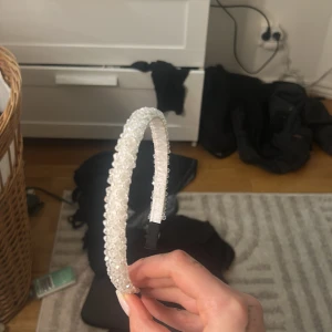 Vitt diadem med pärlor - Snyggt vitt diadem dekorerat med pärlor som ger en glittrig och elegant look. Perfekt accessoar för att lyfta din outfit och ge lite extra bling till håret. Diademet har en normal passform och är bekvämt att bära hela dagen. Säljer billigare för smink fläken på!