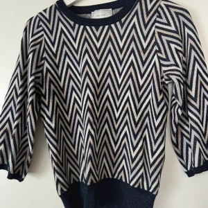 Glitter tröja från Neo Noir - Säljer en snygg stickad tröja från Neo Noir i storlek 36. Tröjan har ett zigzag-mönster lite missoni vibe, med glittriga detaljer. 