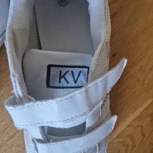 Vita sneakers med kardborreband från KV - Säljer ett par vita sneakers från( kriminalvården )  KV. Till någon som samlar på sånt