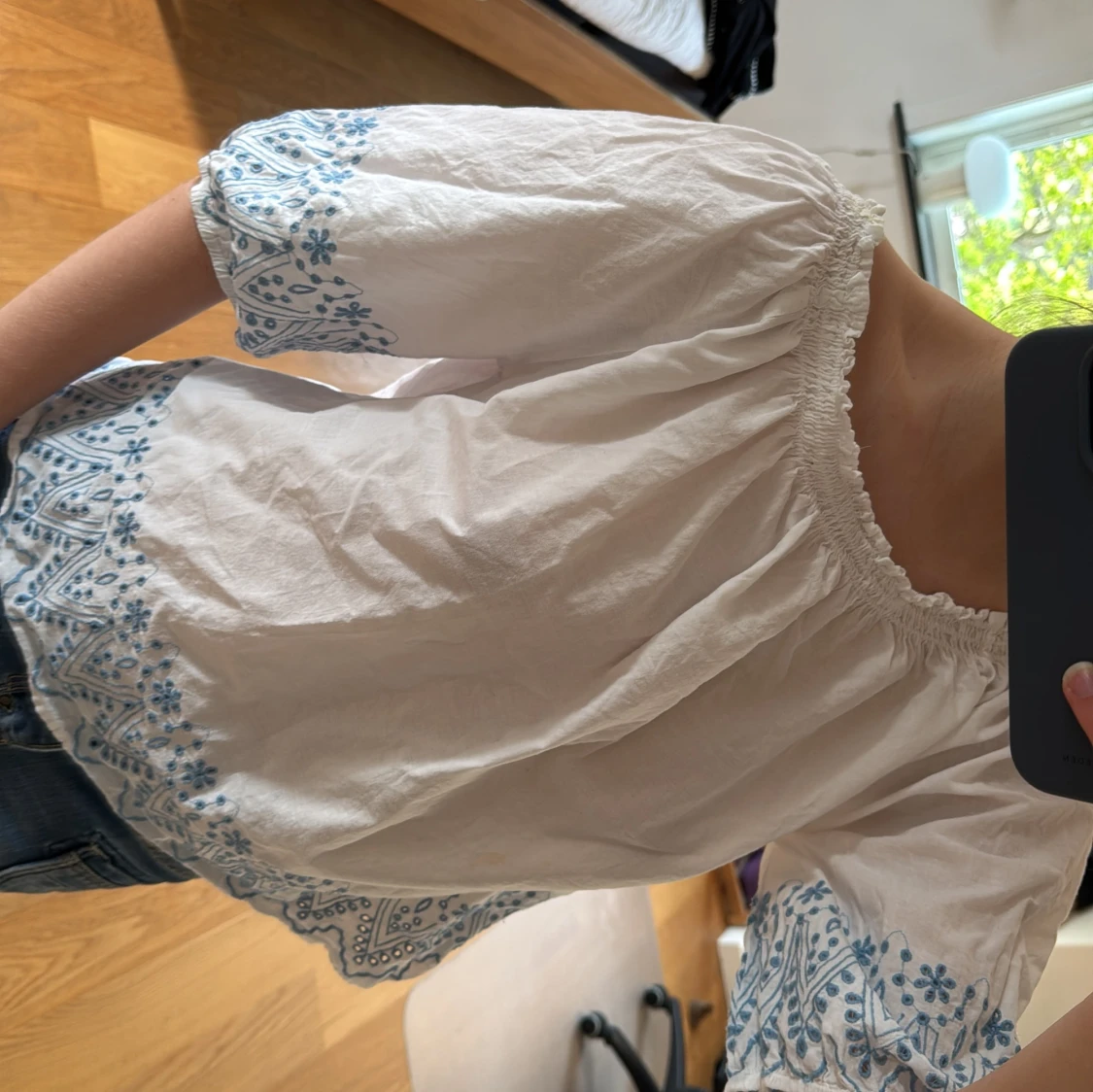 Vit blus med blått mönster