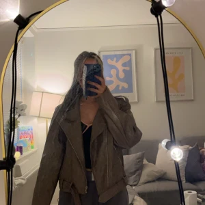 Brun skinnjacka med bälte - Säljer en brun skinnjacka med cool asymmetrisk dragkedja och bälte i midjan. Jackan har bred krage och axelklaffar 🧚🏽