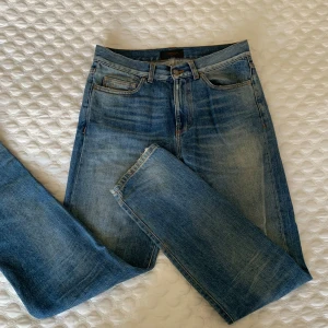 Blå jeans från J.Lindeberg - Snygga blå jeans från J.Lindeberg med klassisk femficksdesign och normal passform. Snygga blekningar och ett allmänt sköna jeans