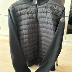 Moncler cardigan black label - Hej!  Säljer nu denna snygga Moncler cardigan. Knappt använd från det att jag fick den i julklapp. Inga defekter.  Har tyvärr inget kvitto men kan säkerhet ställa att den är äkta.  Det står att det är L men passar mer som en M-S. Finns att hämta i Saltsjöbaden eller frakta. 