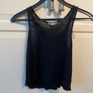 Svart croppad linnetopp från Forever 21 - Säljer en svart croppad linnetopp från Forever 21. Toppen är ärmlös med rund halsringning och tillverkad i ett tunt, lätt material som passar perfekt till varma dagar eller träningen. 