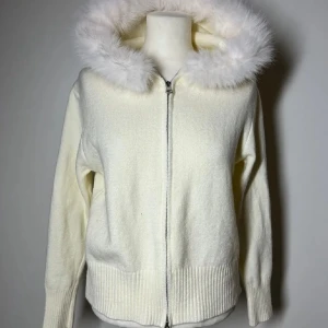 Stickad tröja med päls krage  - Superfin och populär stickad zip up med päls. Köpte här på plick för 700kr och den är helt ny och oanvänd. Vet dock inte vart den kommer ifrån. Vit/cremefärgad. Köp sker via köp nu, jag postar inom 24h. Kvar tills markerad såld 
