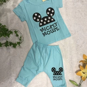 Barn T Shirt med Shorts  - Ljusblå t-shirt med stort gult smiley-tryck och texten 'Smile' på bröstet. Matchande ljusblå shorts med mindre smiley-tryck och text på ena benet. Perfekt för en avslappnad och glad stil. 119kr/paket /2delar 