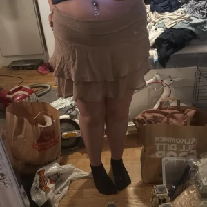 Beige volangkjol från SHEIN - Säljer en beige kjol från SHEIN med volangdetaljer och elastisk midja. Kjolen är kort och har en flowy passform som ger en avslappnad och trendig look. Perfekt för dig som gillar lager på lager och mjuka material. (Kan ha dem som en tröja också)