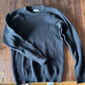 Svart stickad tröja med rund hals - En enkel och stilren svart stickad tröja med rund halsringning. Tröjan har långa ärmar och är perfekt för lager-på-lager under kyligare dagar. Passar till det mesta och är ett måste i garderoben.