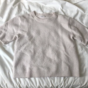  stickad kortärmad tröja  - Mysig ljusrosa stickad tröja från Kappahl med korta ärmar och rund halsringning. Perfekt för lager-på-lager och passar till många olika stilar. Ribbstickade muddar vid ärmslut, hals och nederkant.