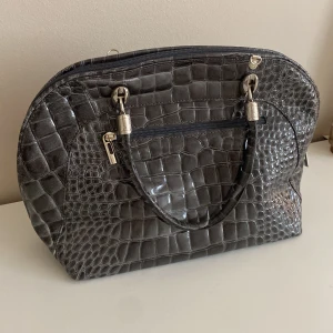 Grå handväska i äkta skinn - Säljer en grå handväska i äkta skinn från Borse in Pelle, tillverkad i Italien. Väskan har krokodilmönster silver detaljer. Hör av er om ni har frågor eller prisförslag 💞