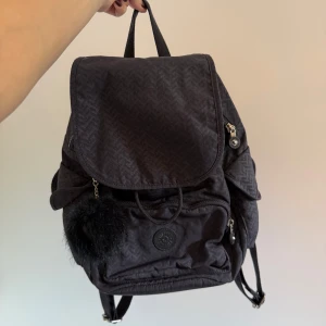 Kipling City Bag ryggsäck - Säljer en marinblå ryggsäck från Kipling i nyskick! Massor av fack med knapp och dragkedja. Perfekt liten skolväska eller liten vardagsväska! Nypris ca 1000kr