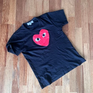 Comme des garcons PLAY t-shirt - CDG PLAY t-shirt – I mycket fint skick! 👕 Märke: Comme des Garçons PLAY ✨ Skick: Nästan som ny – inga synliga spår av användning 📏 Storlek: Märkt som M, men passar bättre som XS–S ✅ Äkthet: Äkta vara, legit check finns vid behov  ❗️Fråga gärna eller ge ett bud! – Först till kvarn! 