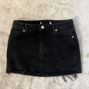 Svart jeanskjol med fransig kant - Säljer en svart super fin jeanskjol med fransig kant där nere. Tyvärr är lappen borttagen och kommer inte ihåg storlek. Men midjemåttet rakt över är ca 35 cm och längden är ca 31 cm. Använd fåtal gånger så är i fint skick! Hör av er för fler bilder💞
