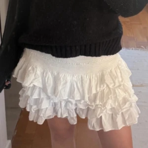 Vit volangkjol från H&M - Supersöt vit kortkjol från H&M med flera lager volanger och bred resår i midjan. Storlek xs men passar även större