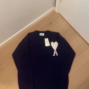  stickad Ami Paris - En riktigt fet marinblå Ami Paris tröja som passar till sköna sommarkvällar. Den är stickad och är av högsta kvalitet. Otroligt skön och snygg. Perfekt inför en båttur på en sommarkväll 🌅 