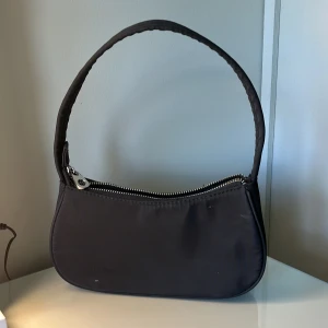 Svart väska - Svart väska från Pull&Bear. Säljer pga att den inte används mer. Två pyttesmå fläckar på men det syns inte! Köpt för 200 kr