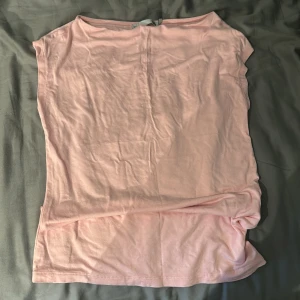 Ljusrosa enkel t-shirt/topp - Säljer en ljusrosa t-shirt/topp i mjuk bomull. Modellen är rak och har korta ärmar med en klassisk rund halsringning. Perfekt för en avslappnad stil.