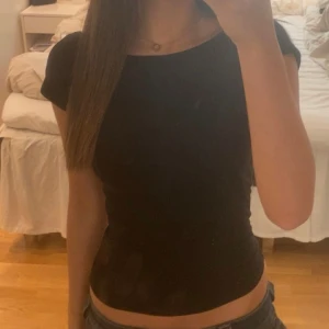 Svart tight t-shirt - En enkel svart tight t-shirt med rund halsringning. Perfekt basplagg som passar till det mesta. Kortärmad och i mjukt material. Från hm 