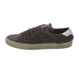 Svarta sneakers från Saint Laurent - Svarta sneakers från Saint Laurent med slitna detaljer och vit hälkappa. Ovandelen är i denimliknande material med fransiga kanter och svarta skosnören. Klassisk rund tå och platt sula i beige. Perfekta för en avslappnad grich stil.