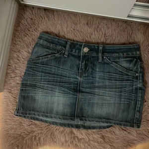 Mörkblå jeanskjol med fickor - Säljer en skit snygg mörkblå jeanskjol med klassiska fickor fram och bak. Kjolen har en kort passform och stängs med knapp och dragkedja framtill. Är från amisu i storlek 36, säljer pågrund av att den är lite för stor på mig. Hör av dig om du har frågor eller funderingar💕