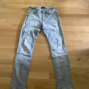 Ljusgrå slim jeans från Jack & Jones - Säljer ett par ljusgrå slim fit jeans från Jack & Jones, modell Glenn. Jeansen har klassisk femficksdesign, smal passform och är tillverkade i mjukt bomullsmaterial med stretch. Perfekta för dig som gillar en clean och modern look.