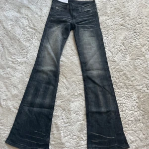 Svarta bootcut jeans med slitningar - Snygga svarta jeans med bootcut passform och coola slitningar framtill. Från cheap monday i strlk 26/32