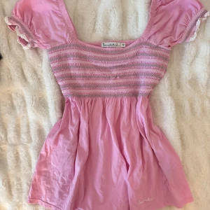 Rosa babydoll topp - Super gullig rosa babydoll topp med smockad bröst och fina puffärmar, storlek M men liten i storleken!