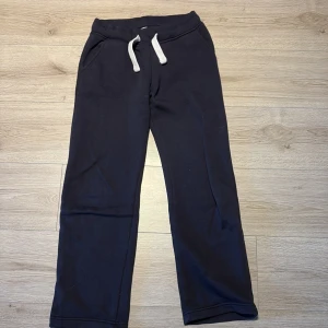 Mörkblå mjukisbyxor från russemerch - Svarta mjukisbyxor från Russemerch i storlek XS. Byxorna har vita snören i midjan, raka ben och är låg midjade. Byxorna har dock små fett fläckar på vänstra knät men inget man tänker på.