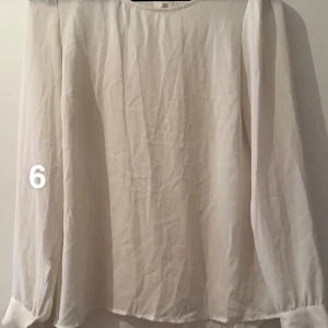 Vit långärmad blus i chiffong - Stilren vit blus med långa ärmar och rund halsringning. Tunt, lätt och luftigt tyg som ger en flowy känsla. Perfekt att styla med jeans eller kjol för en clean look. 🌸 Fint använt skick. Upplever den som större i stl. Står storlek 6 vilket skulle motsvara xs enligt tabell