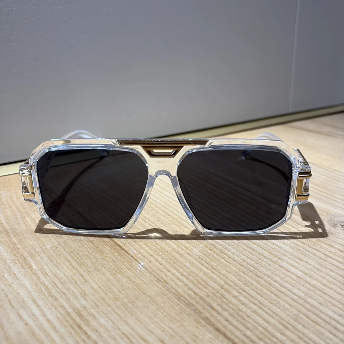 Transparenta solglasögon med guldiga detaljer