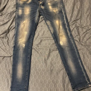 Philipp Plein skinny jeans blå - Säljer ett par blå jeans från Philipp Plein med slitna detaljer och blekta detaljer. logopatch på bakfickan och smal passform. Perfekta för dig som gillar en streetstil.       Fraktar